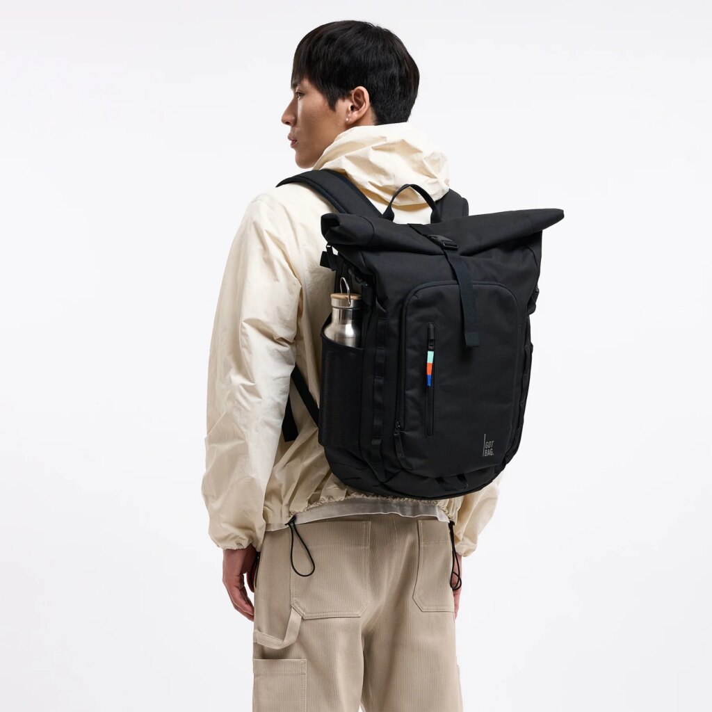 ROLLTOP ADVENTURE Rucksack in black (Schwarz) von einem Mann als Rucksack auf dem Rücken getragen.