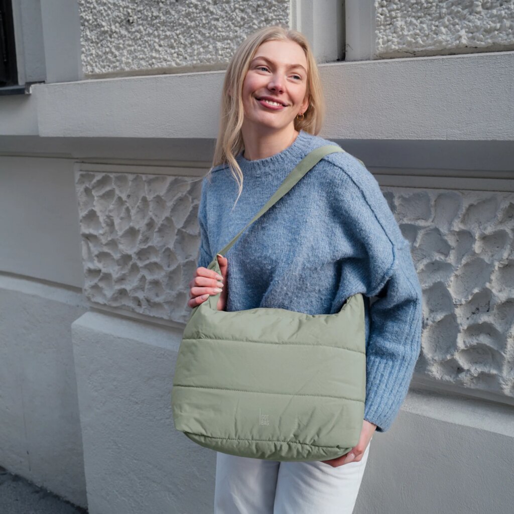 PUFFER SQUARE BAG Tasche in oyster (klassisches Taupe-Braun) von einer Frau crossbody getragen.