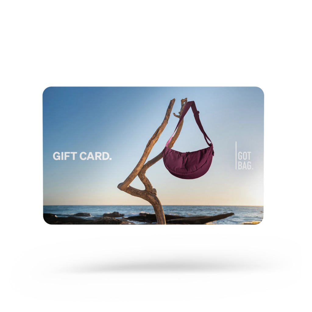 GIFT CARDS Accessoire mit einer Tasche, die an Treibholz an einem sonnigen Meer hängt.