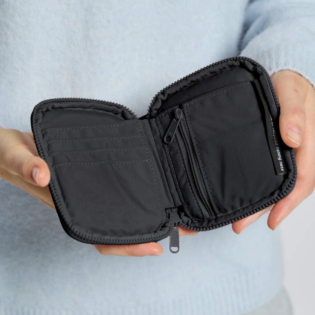 WALLET Accessoire in black (Schwarz) von einer Person in den Händen gehalten.