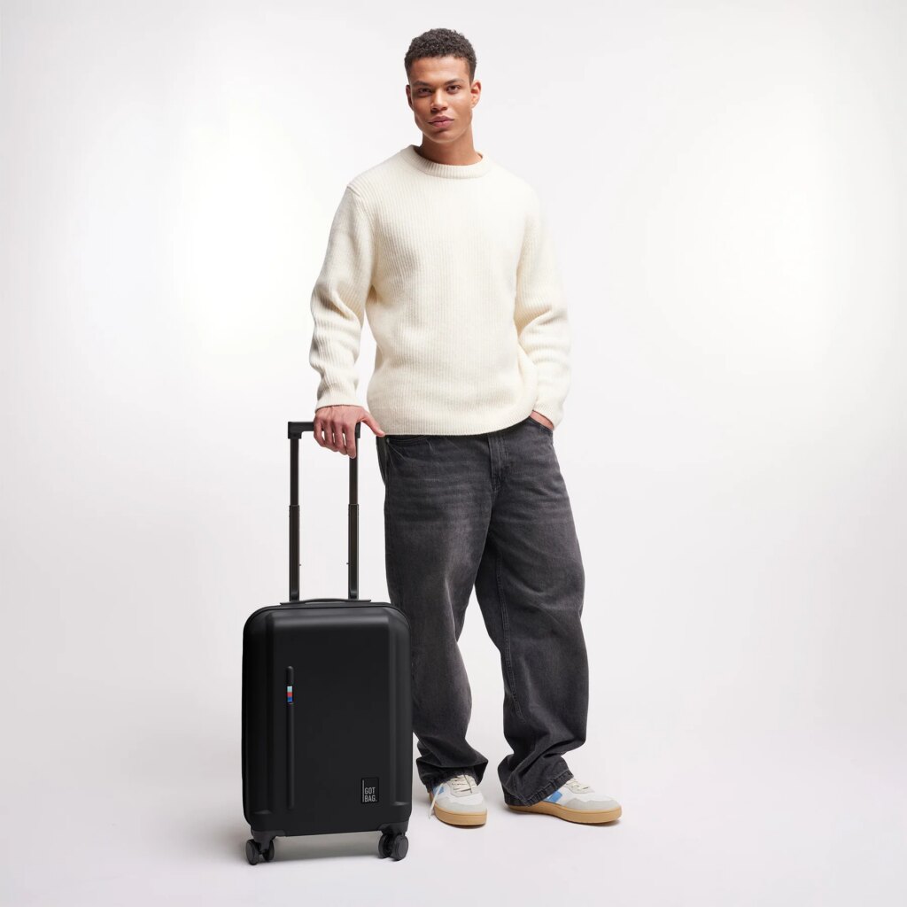 RE-SHELL CABIN 3.0 Koffer in black (Schwarz) von einem Mann in der Hand gehalten.