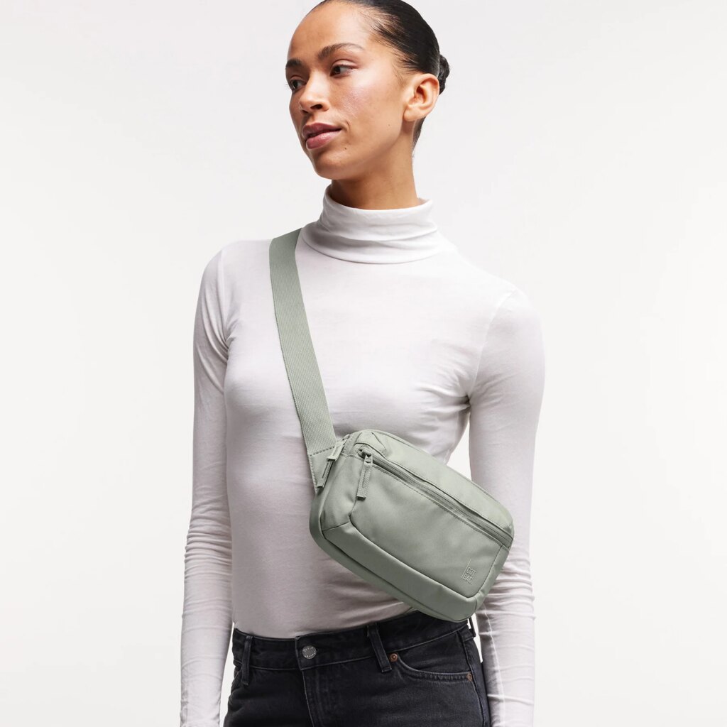 SLING BAG Tasche in bass (Salbeigrün) von einer Frau crossbody getragen.