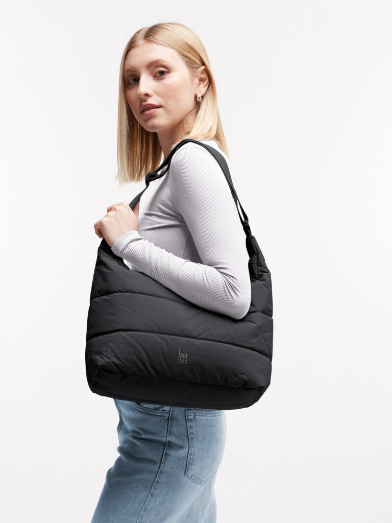 PUFFER SQUARE BAG Tasche in scallop (helles Beige) von einer Frau über der Schulter getragen.