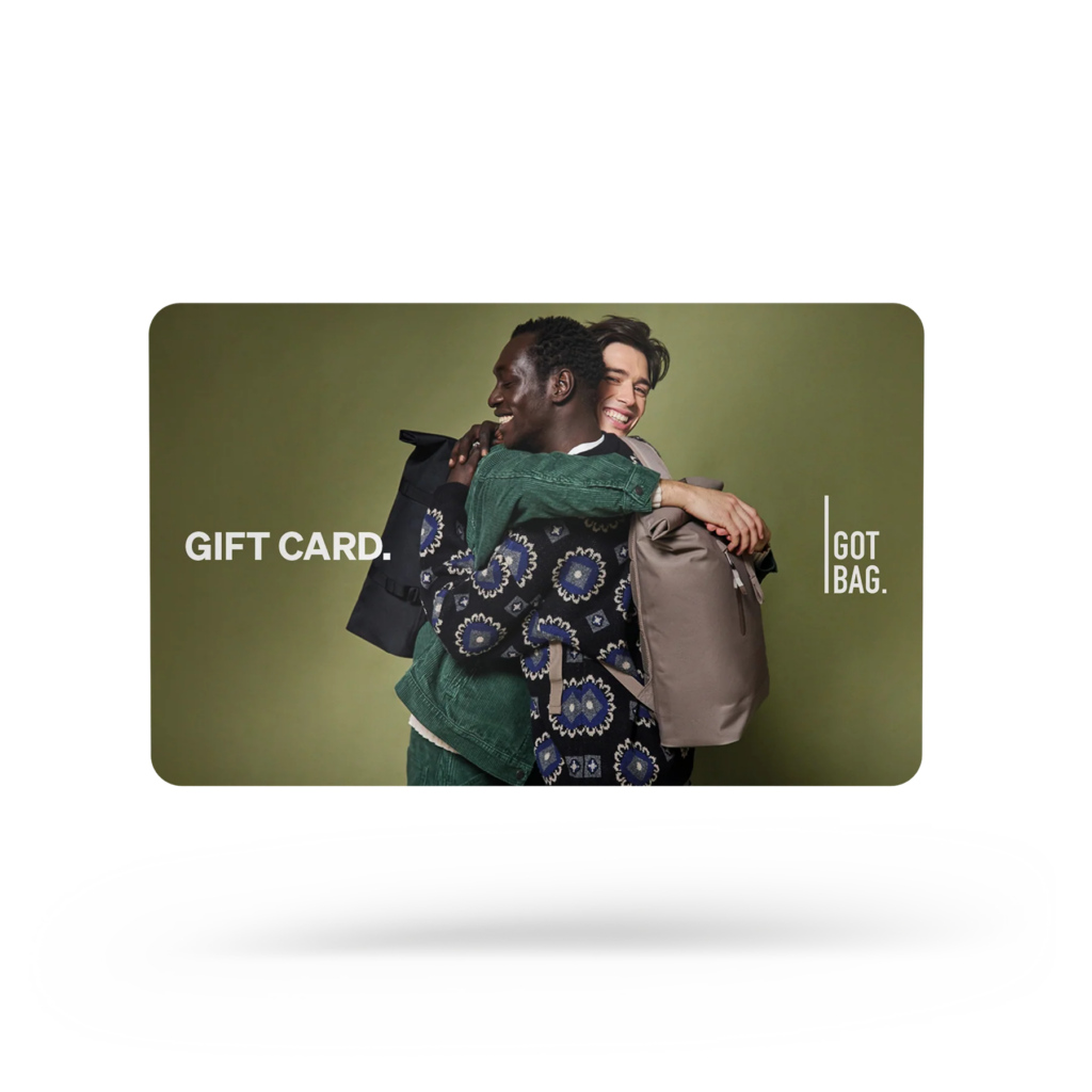 GIFT CARDS Accessoires mit zwei Männern, die sich umarmen und Rucksäcke auf dem Rücken tragen.