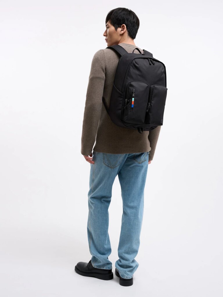 BASE PACK Rucksack in black (Schwarz) von einem Mann auf dem Rücken getragen.